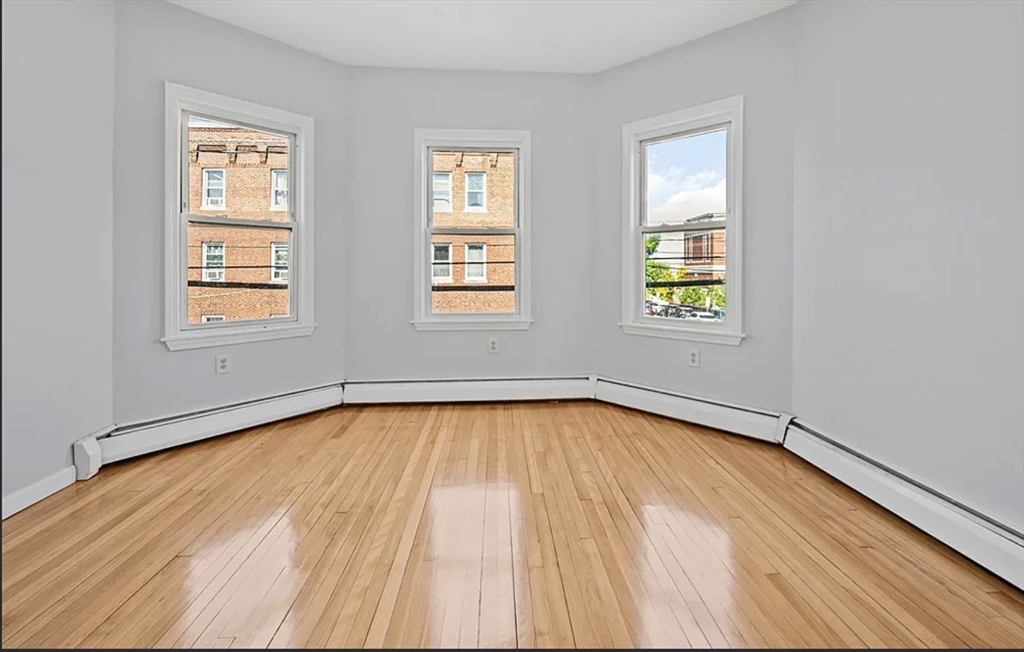 61 Shurtleff Street, Unit 4 Chelsea, MA 02150 - Photo 17 of 22 an empty room with wooden floor and windows