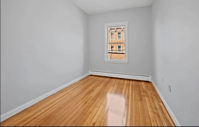 a view of a room with wooden floor and window