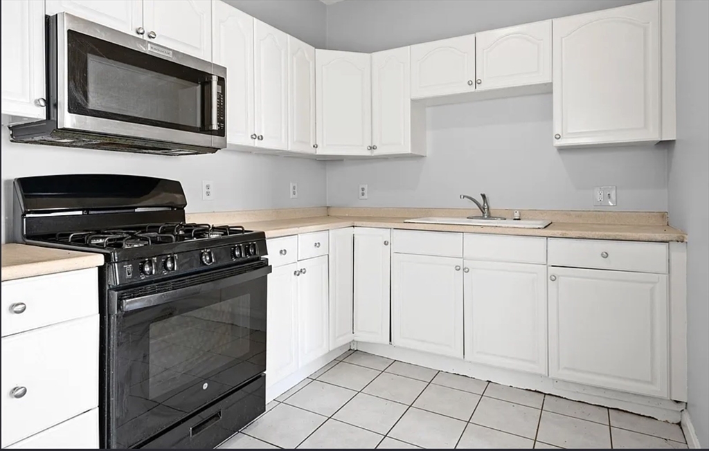 61 Shurtleff Street, Unit 4 Chelsea, MA 02150 - Photo 2 of 22 a kitchen with white cabinets stainless steel appliances and sink