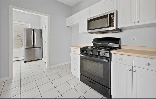 a kitchen with cabinets stainless steel appliances and a counter top space