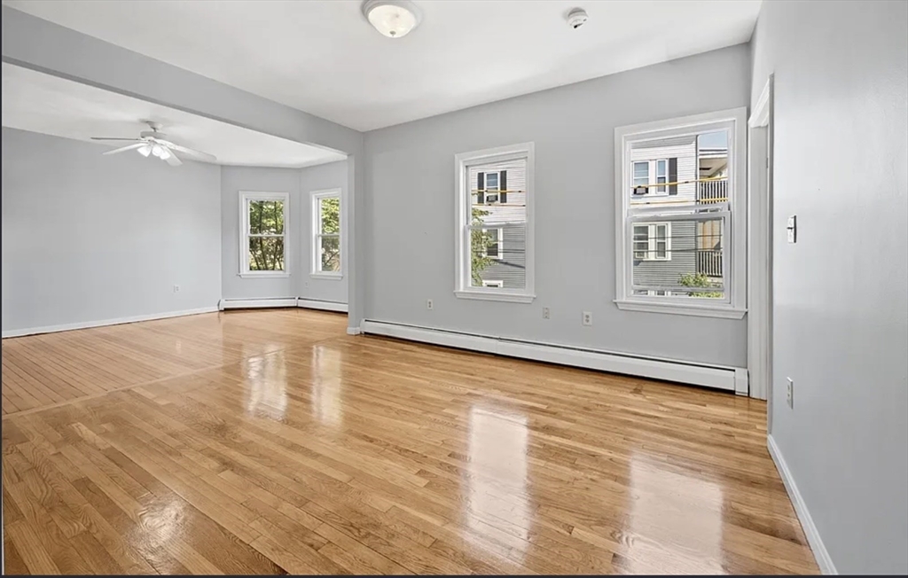 61 Shurtleff Street, Unit 4 Chelsea, MA 02150 - Photo 7 of 22 a view of an empty room with a window and wooden floor