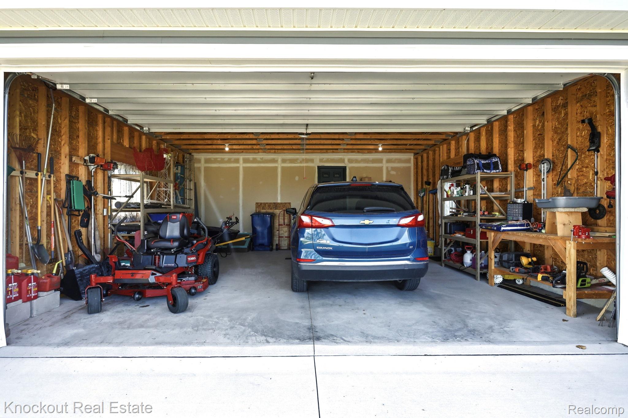 5727 Mackinaw Road Saginaw, MI 48604 - Photo 35 of 60 Attached two-car garage with concrete flooring, exposed wood framing, and overhead lighting