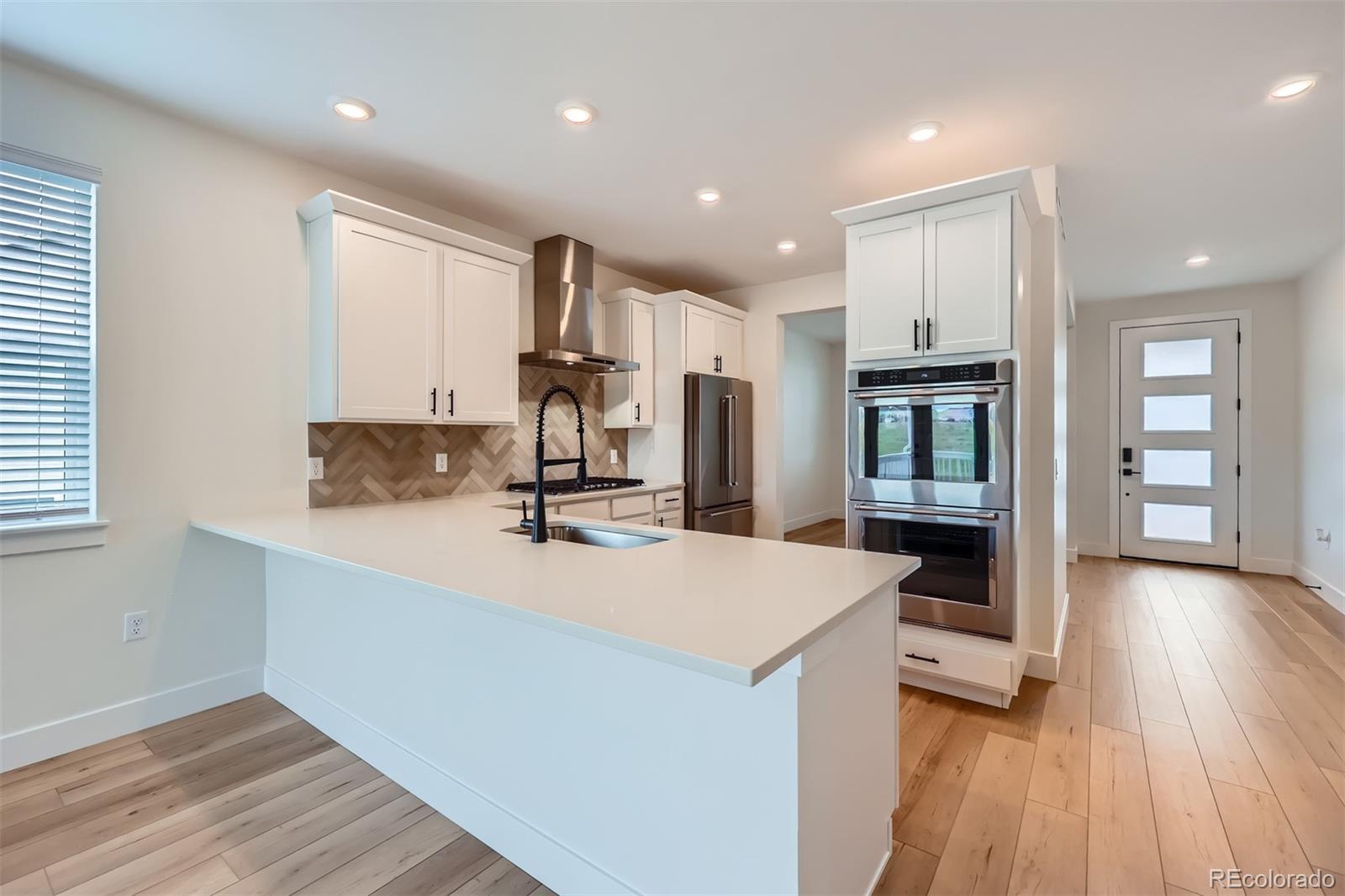 42982 Colonial Trail Elizabeth, CO 80107 - Photo 7 of 31 a large kitchen with stainless steel appliances a large counter top a stove and a wooden floors
