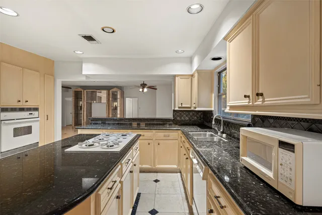 a kitchen with a stove sink and cabinets