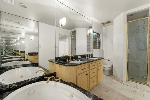 a bathroom with a sink a toilet a mirror and shower