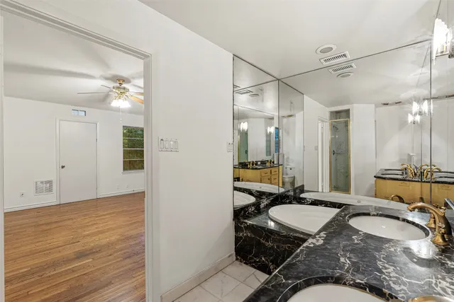 a bathroom with a granite countertop sink a mirror and shower