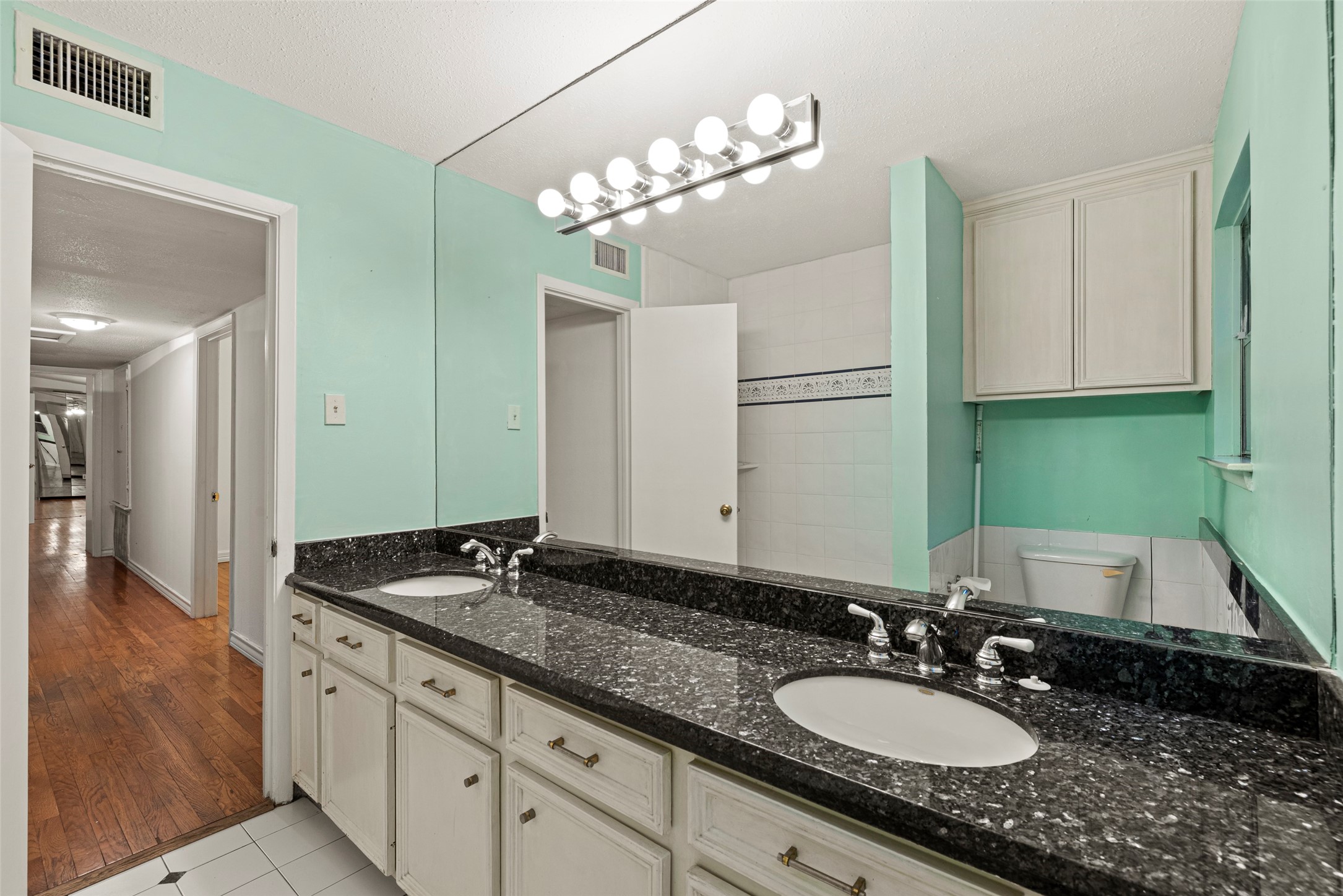 2927 Rockyridge Drive Houston, TX 77063 - Photo 23 of 34 a bathroom with a granite countertop double vanity sinks a vanity and a mirror