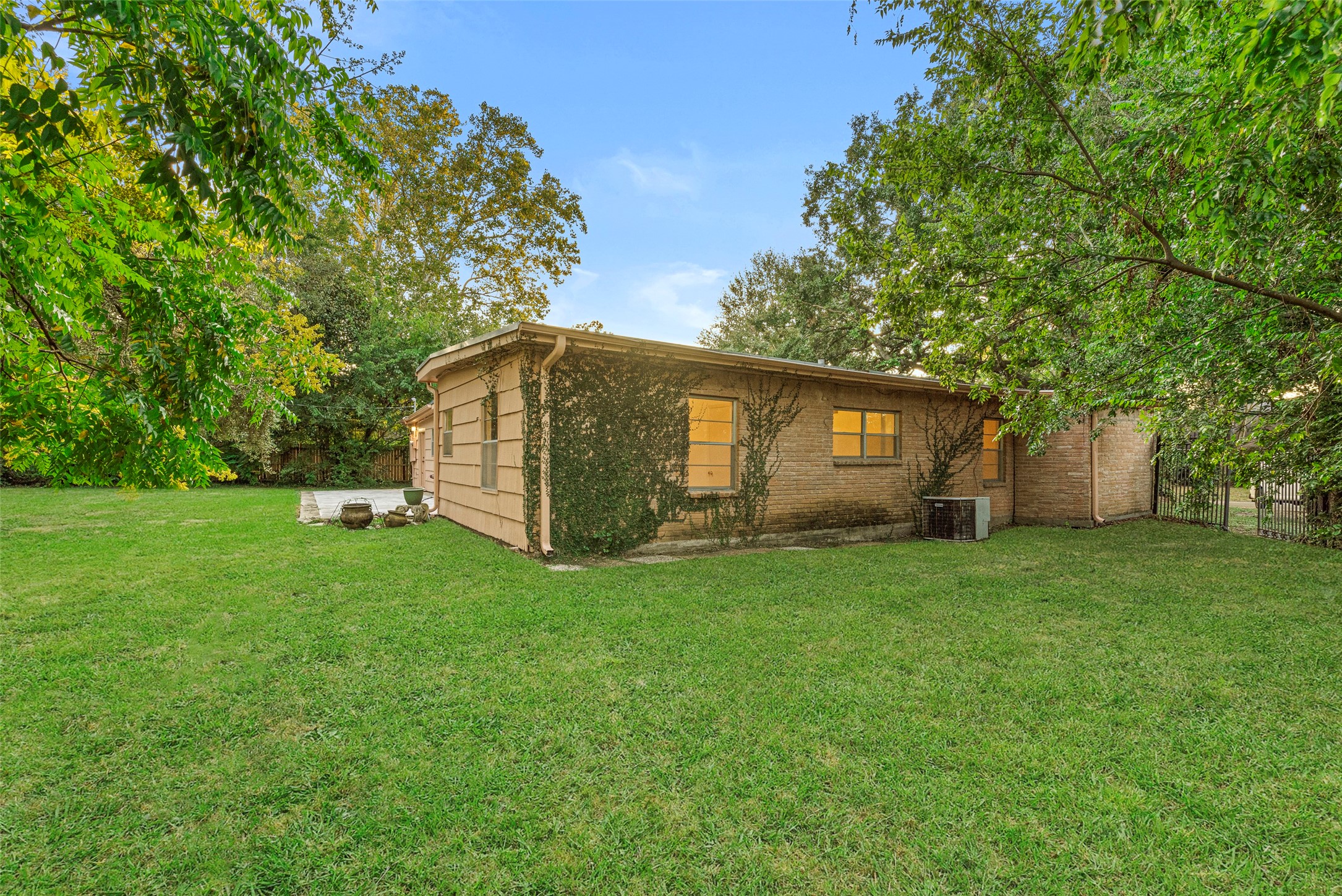 2927 Rockyridge Drive Houston, TX 77063 - Photo 28 of 34 a backyard of a house with large trees and plants