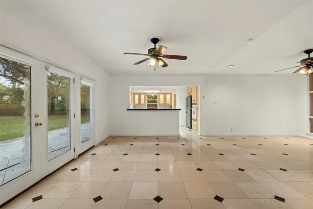 a view of a hallway with a chandelier fan and windows