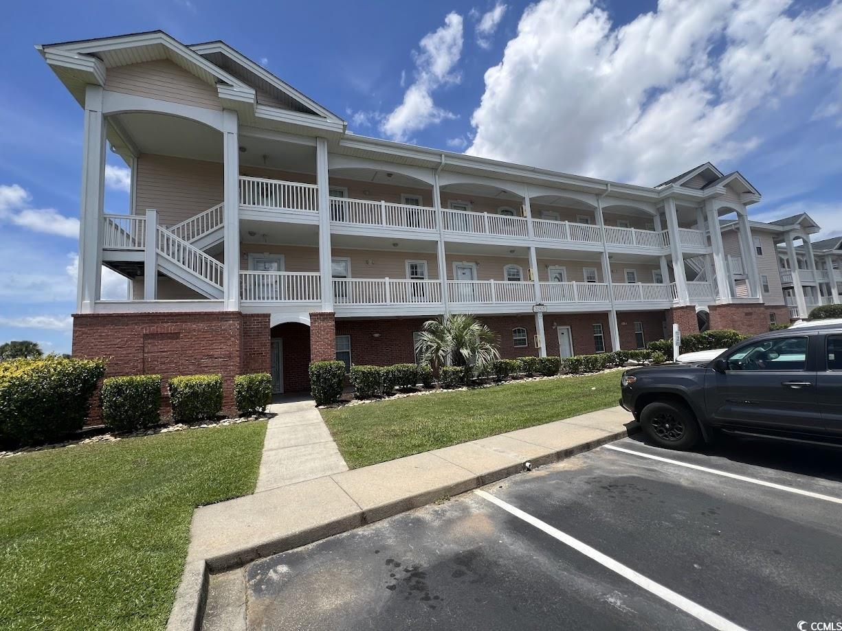 View of building exterior featuring uncovered parking