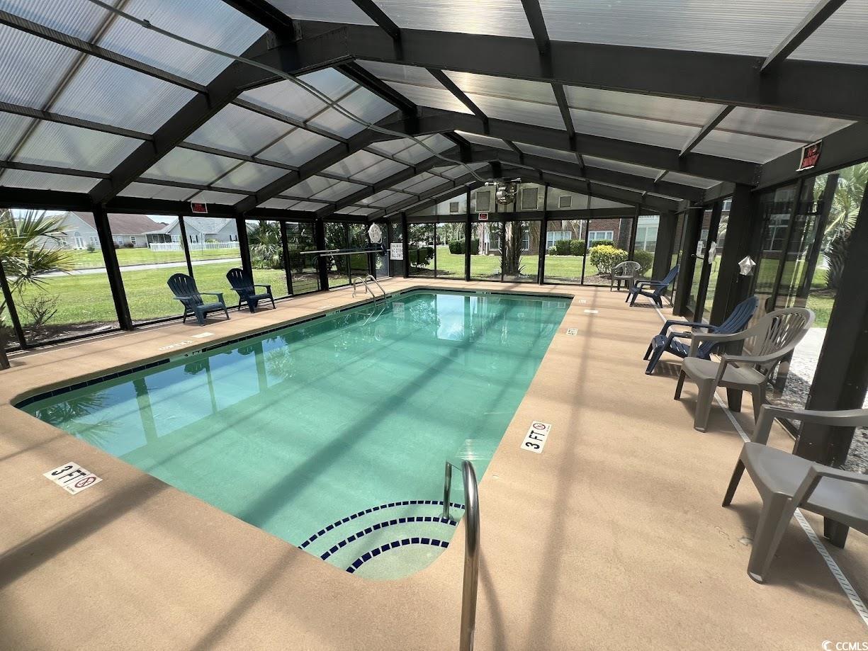3965 Forsythia Court, Unit 202 Myrtle Beach, SC 29588 - Photo 12 of 15 Indoor community pool featuring a lanai, a lawn, and a patio area