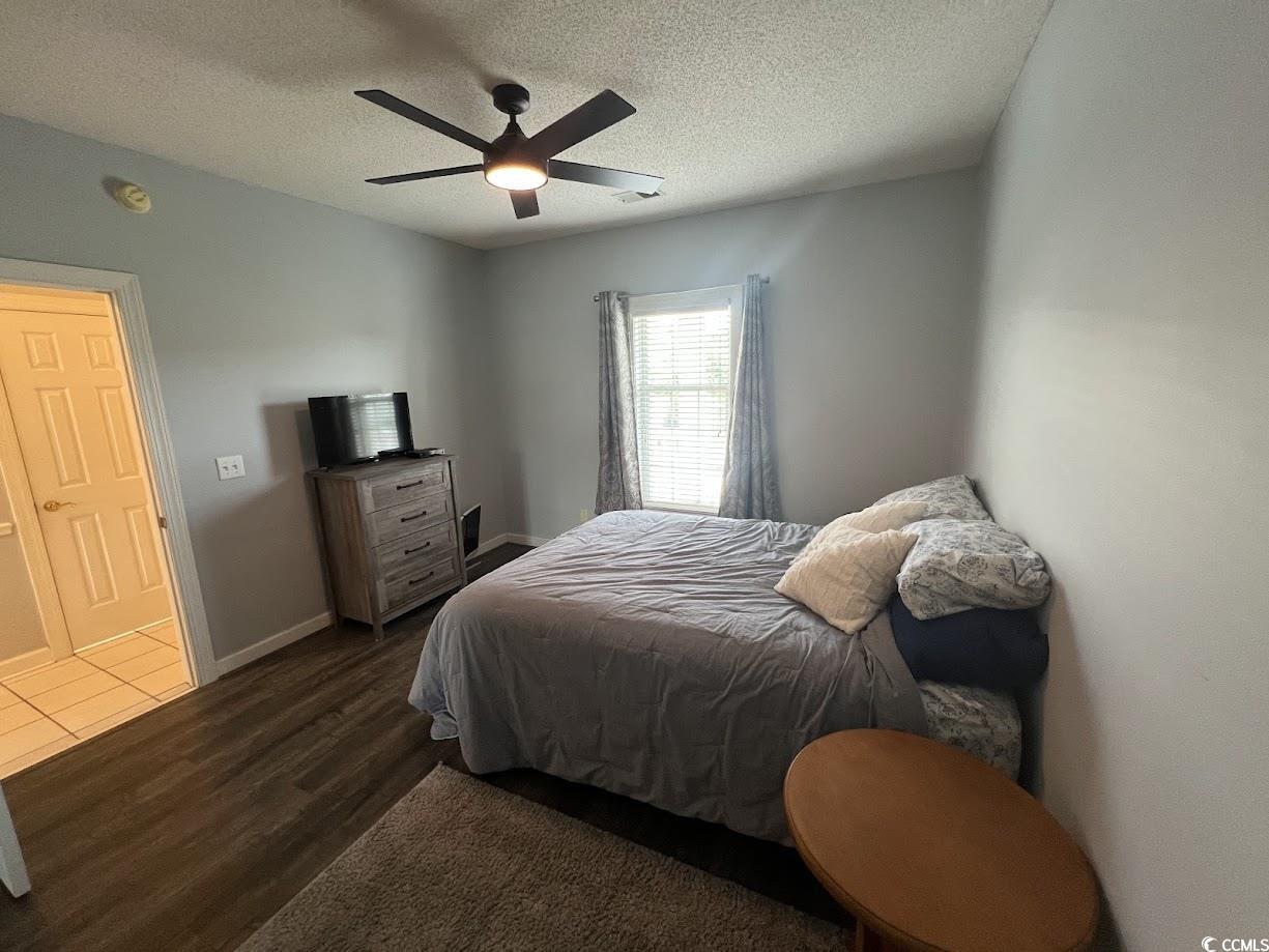 3965 Forsythia Court, Unit 202 Myrtle Beach, SC 29588 - Photo 7 of 15 Bedroom with dark wood-style flooring, a textured ceiling, and a ceiling fan