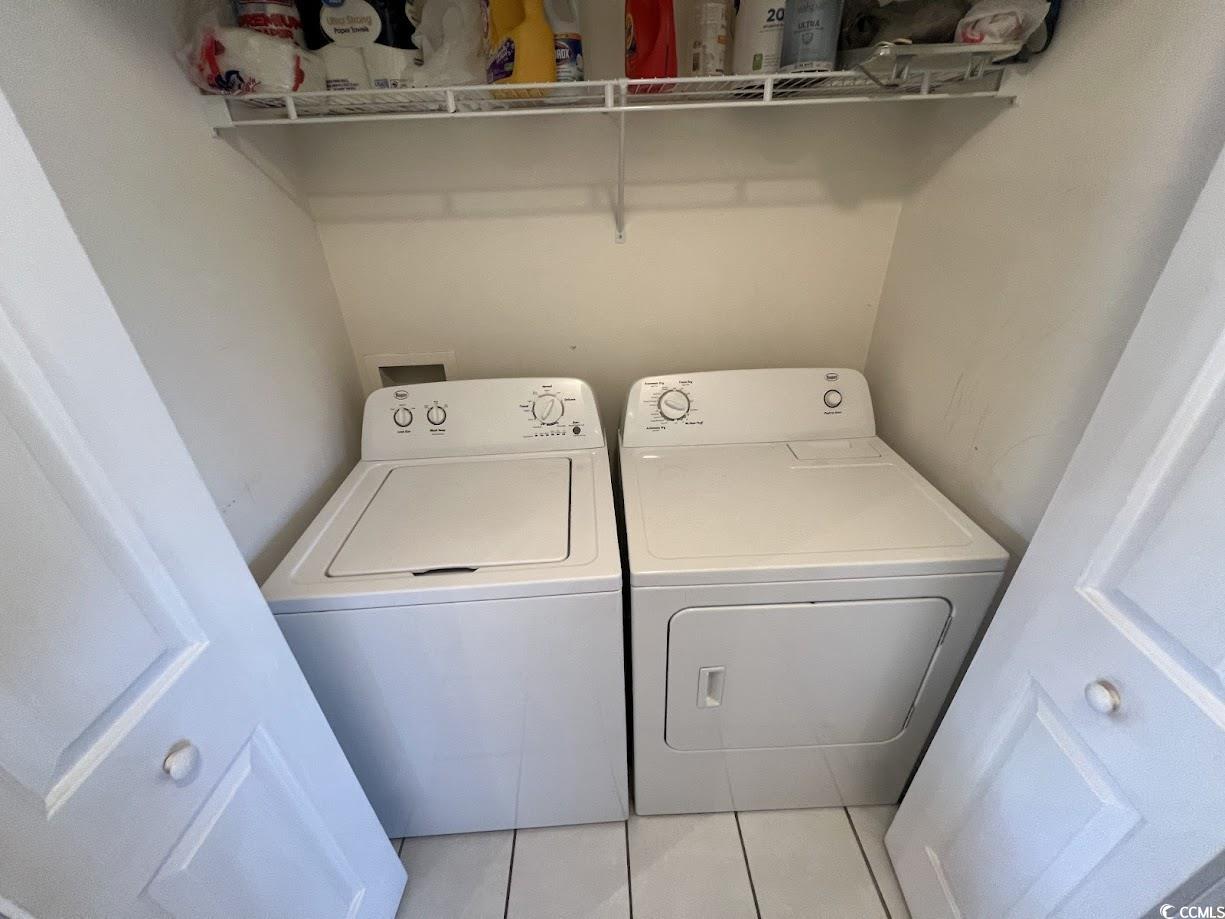 3965 Forsythia Court, Unit 202 Myrtle Beach, SC 29588 - Photo 9 of 15 Laundry area with washing machine and clothes dryer and light tile patterned flooring