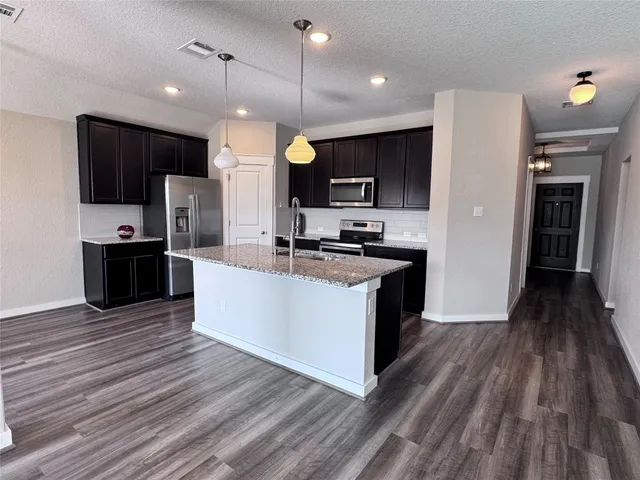 a kitchen with stainless steel appliances granite countertop a sink and a microwave