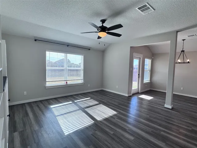 a view of a kitchen with wooden floor a ceiling fan and windows