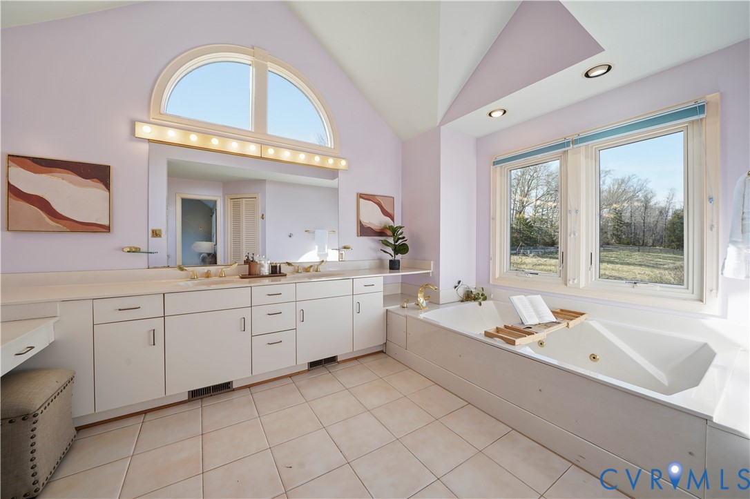 805 Rockford Road Manakin-Sabot, VA 23103 - Photo 30 of 46 a spacious en suite bathroom with a double vanity sink a mirror and a bathtub next to a window