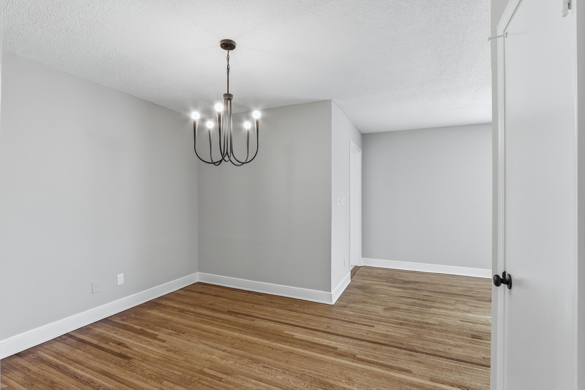 312 Fernway Road Memphis, TN 38117 - Photo 14 of 38 Spare room featuring hanging lights, wood finished floors, and a textured ceiling