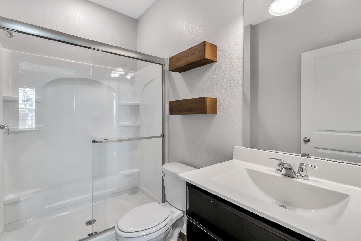 105 Bell Rings Drive Jarrell, TX 76537 - Photo 14 of 22 a bathroom with a sink toilet vanity and shower