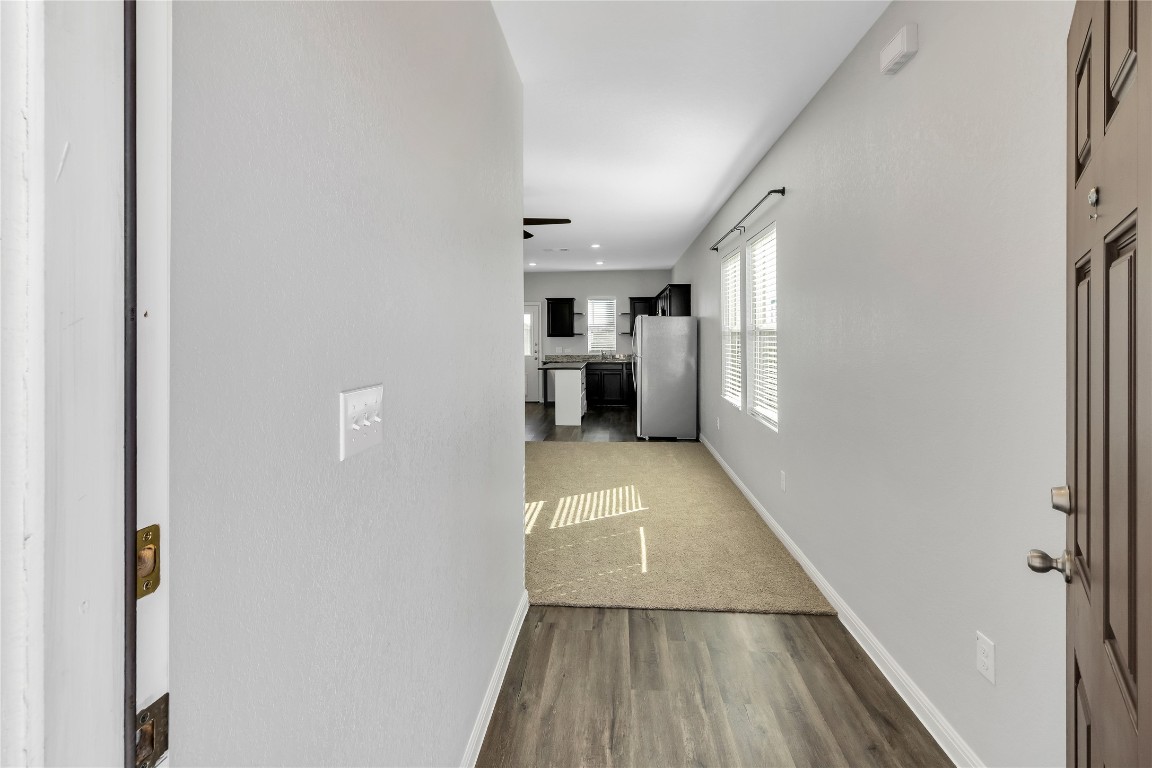 105 Bell Rings Drive Jarrell, TX 76537 - Photo 3 of 22 a view of a hallway to an empty room with wooden floor and a window