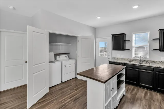 a kitchen with granite countertop a sink stove and refrigerator