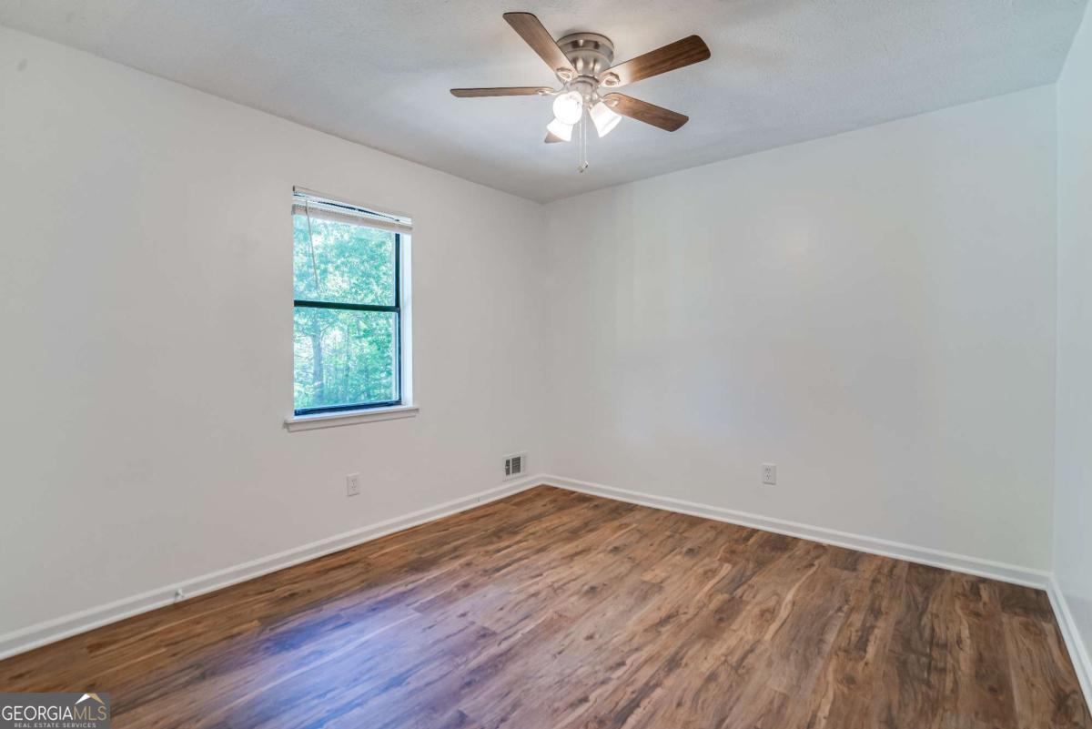 325 Camp Ground Road Griffin, GA 30223 - Photo 13 of 25 a view of empty room with wooden floor and fan
