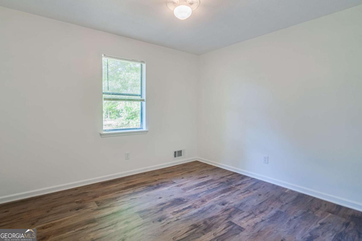 325 Camp Ground Road Griffin, GA 30223 - Photo 15 of 25 an empty room with wooden floor and windows