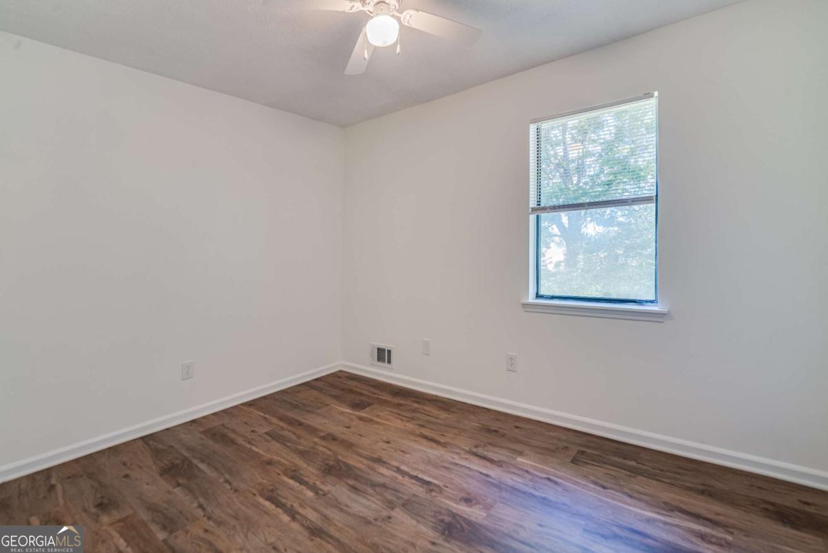 325 Camp Ground Road Griffin, GA 30223 - Photo 17 of 25 an empty room with wooden floor and windows