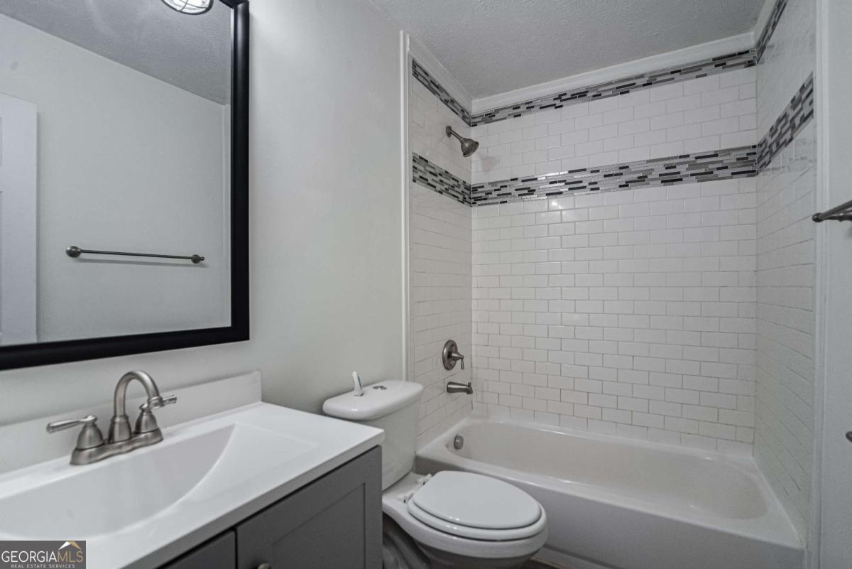 325 Camp Ground Road Griffin, GA 30223 - Photo 18 of 25 a bathroom with a bathtub shower sink vanity mirror and toilet