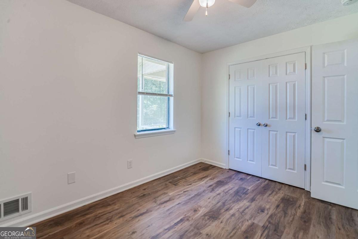 325 Camp Ground Road Griffin, GA 30223 - Photo 20 of 25 an empty room with wooden floor and windows