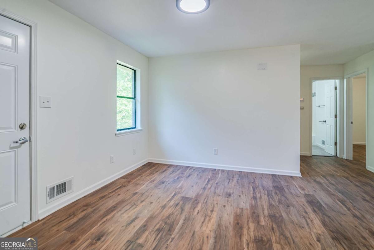 325 Camp Ground Road Griffin, GA 30223 - Photo 6 of 25 an empty room with wooden floor and windows