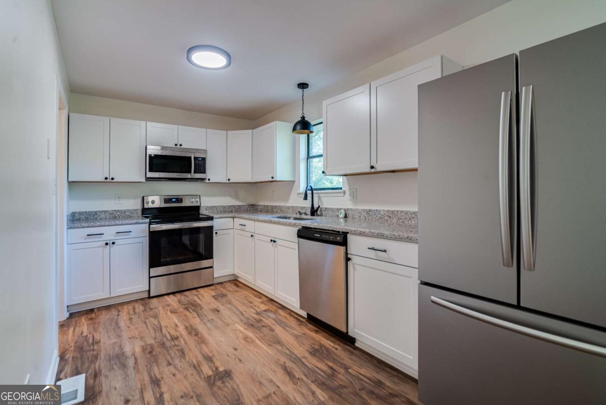 325 Camp Ground Road Griffin, GA 30223 - Photo 8 of 25 a kitchen with granite countertop white cabinets and stainless steel appliances