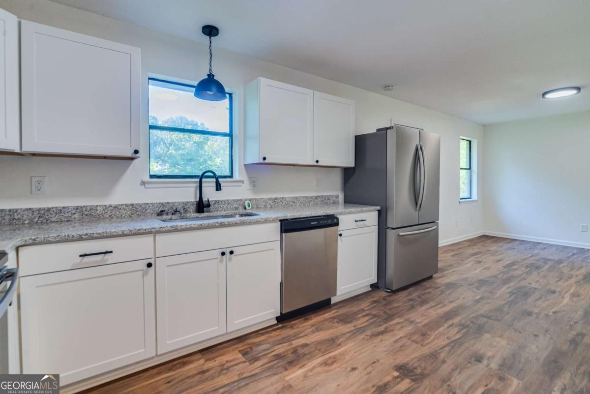 325 Camp Ground Road Griffin, GA 30223 - Photo 9 of 25 a kitchen with stainless steel appliances granite countertop a refrigerator a sink a stove a microwave and island