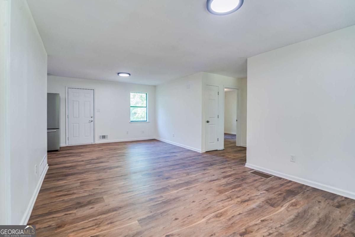 325 Camp Ground Road Griffin, GA 30223 - Photo 10 of 25 an empty room with wooden floor and windows