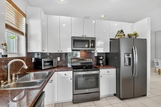 a kitchen with granite countertop a refrigerator stove and sink