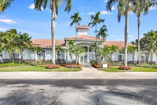 a front view of multi story residential apartment building with yard and sign board