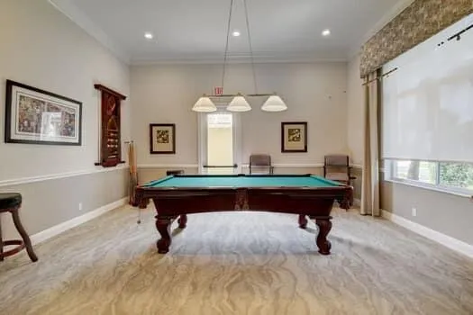 a room with pool table and windows