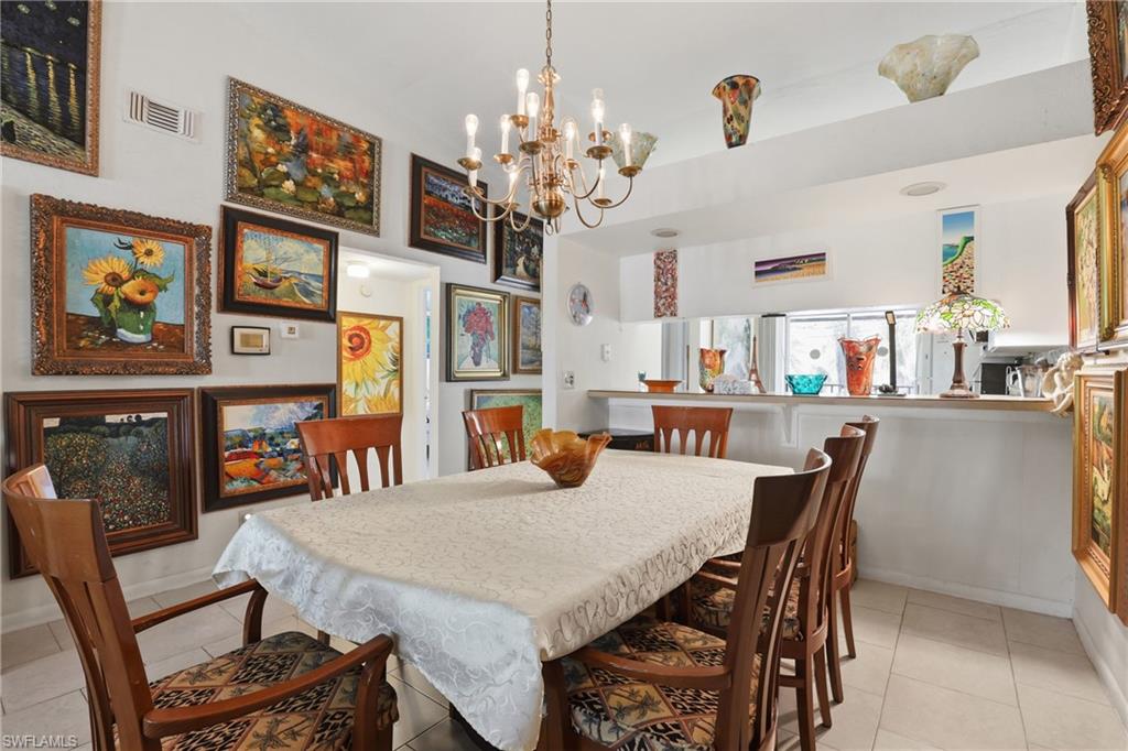 4050 Ice Castle Way, Unit 2812 Naples, FL 34112 - Photo 14 of 49 Dining area featuring a brass chandelier, tile flooring, and a pass-through counter opening