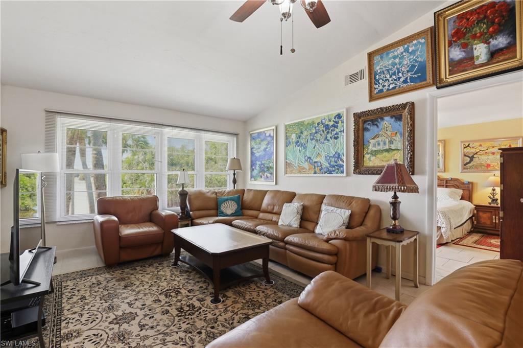 4050 Ice Castle Way, Unit 2812 Naples, FL 34112 - Photo 22 of 49 Vaulted ceiling living area featuring multiple windows, a ceiling fan, and a neutral color palette
