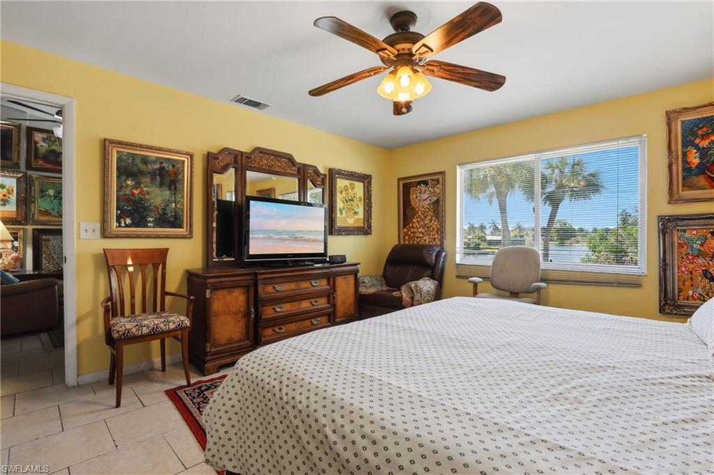 4050 Ice Castle Way, Unit 2812 Naples, FL 34112 - Photo 28 of 49 Room featuring tiled flooring, a ceiling fan with light fixture, and a window offering water views with tropical foliage