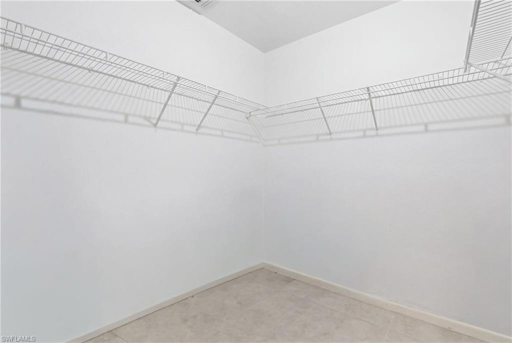 4050 Ice Castle Way, Unit 2812 Naples, FL 34112 - Photo 30 of 49 Walk-in closet featuring white wire shelving, light-toned tile flooring, and white painted walls