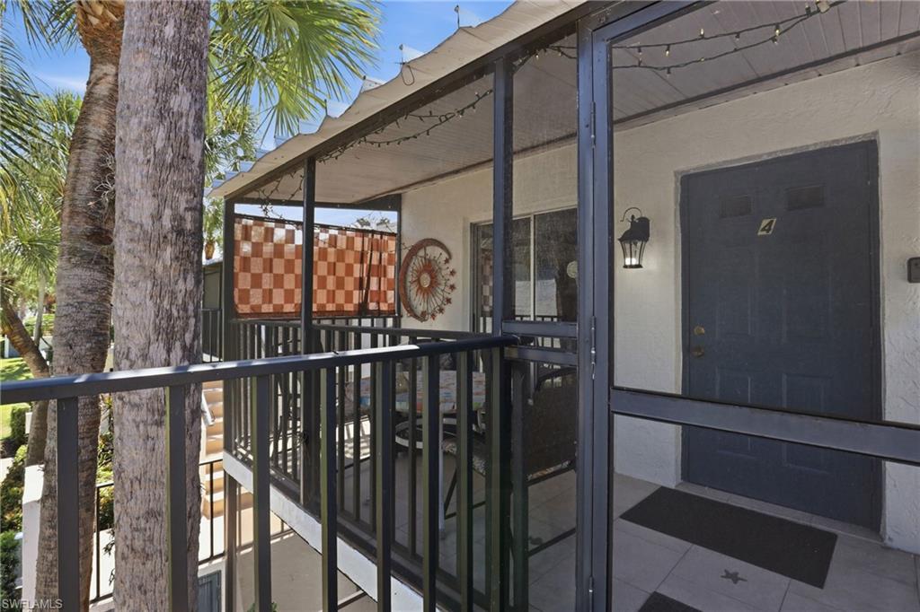 4050 Ice Castle Way, Unit 2812 Naples, FL 34112 - Photo 3 of 49 Screened-in balcony featuring a privacy screen, outdoor lighting, and tile flooring
