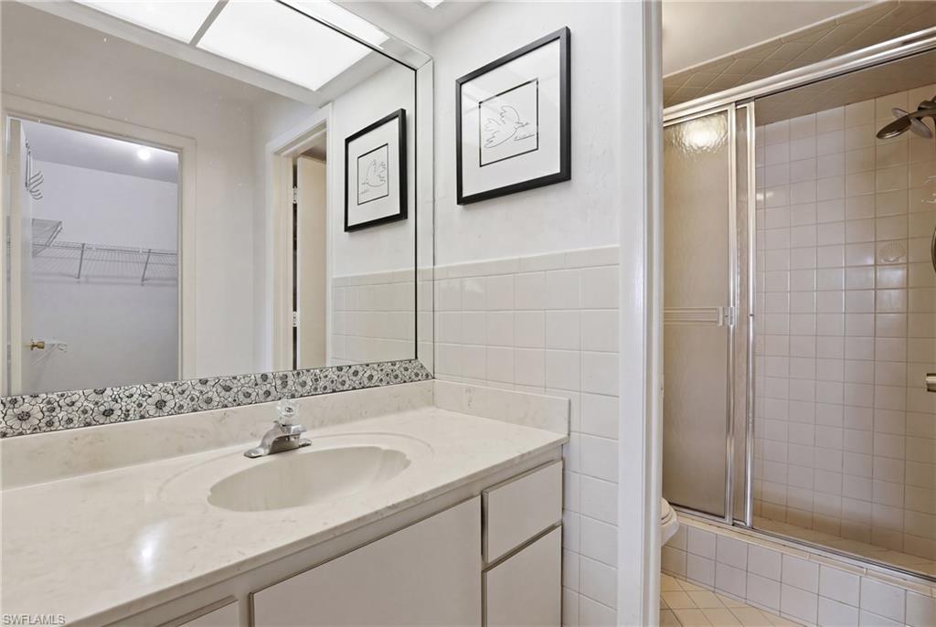 4050 Ice Castle Way, Unit 2812 Naples, FL 34112 - Photo 32 of 49 Bathroom vanity featuring a light-toned countertop with integrated sink, chrome faucet, and a large wall-mounted mirror