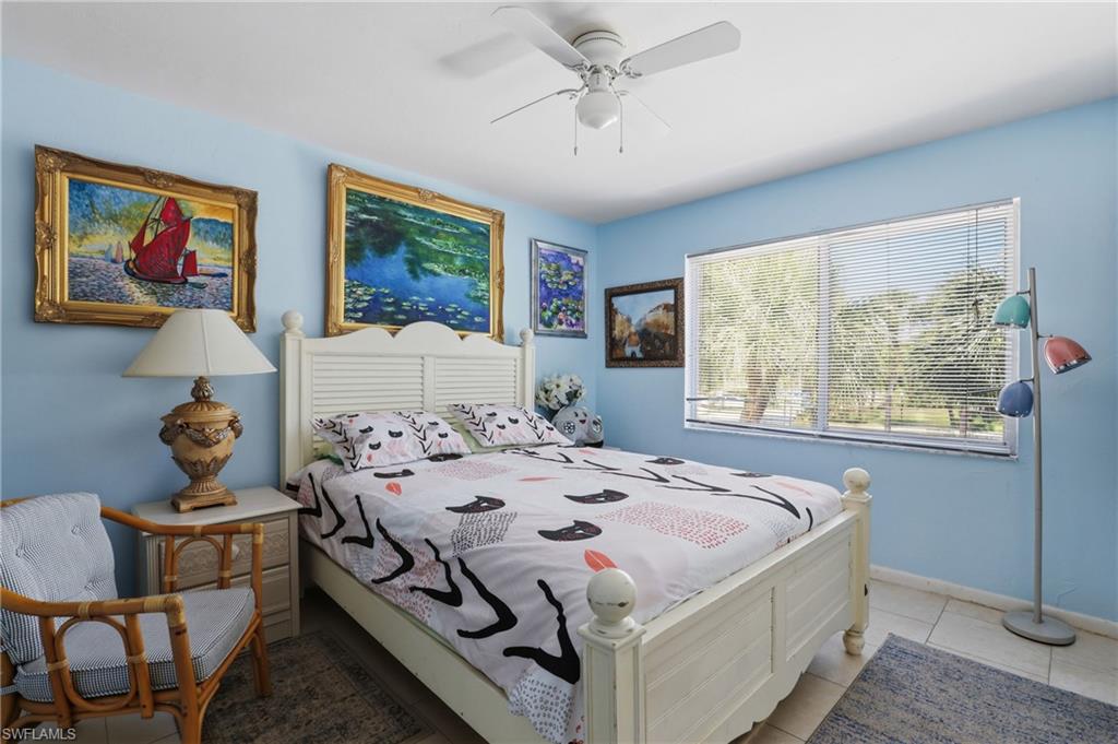 4050 Ice Castle Way, Unit 2812 Naples, FL 34112 - Photo 34 of 49 Bedroom featuring a white louvered headboard, tiled flooring, and a large window with blinds