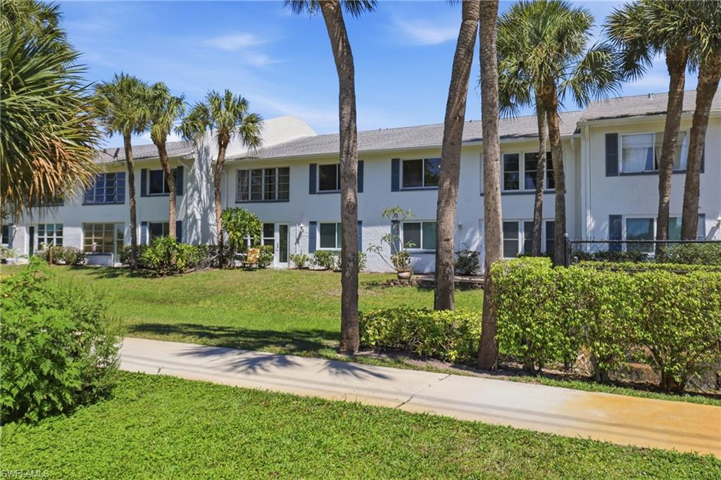 4050 Ice Castle Way, Unit 2812 Naples, FL 34112 - Photo 42 of 49 Two-story white exterior building with multiple windows, dark blue shutters, and a grey roof