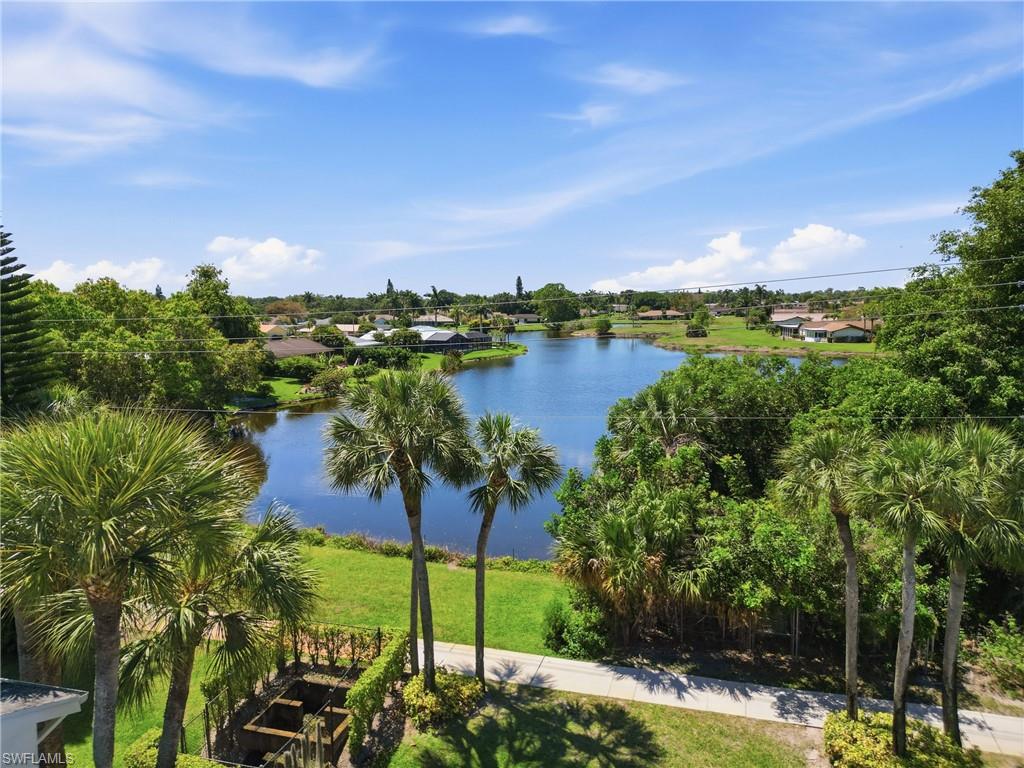 4050 Ice Castle Way, Unit 2812 Naples, FL 34112 - Photo 44 of 49 Expansive water feature bordered by lush green landscaping and mature palm trees