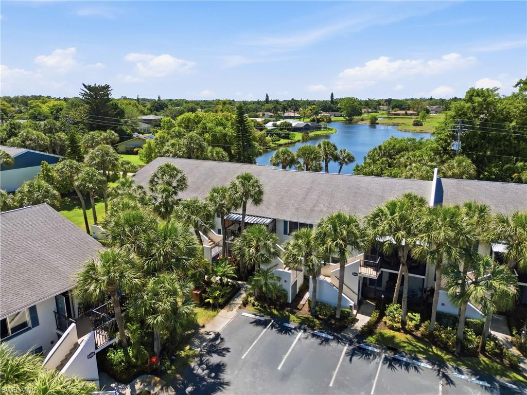 4050 Ice Castle Way, Unit 2812 Naples, FL 34112 - Photo 48 of 49 Multi-story property featuring a lake background and abundant palm trees