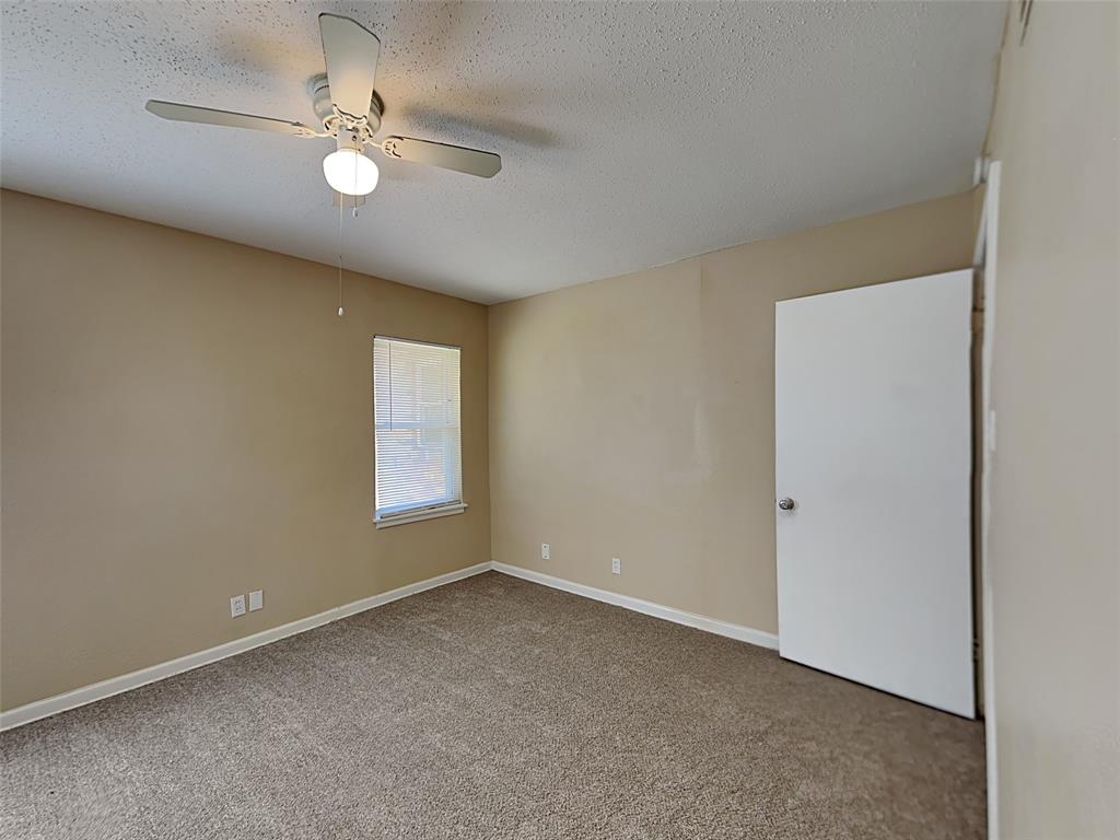 649 West Main Street Lancaster, TX 75146 - Photo 3 of 14 Spare room with light colored carpet, a textured ceiling, and ceiling fan