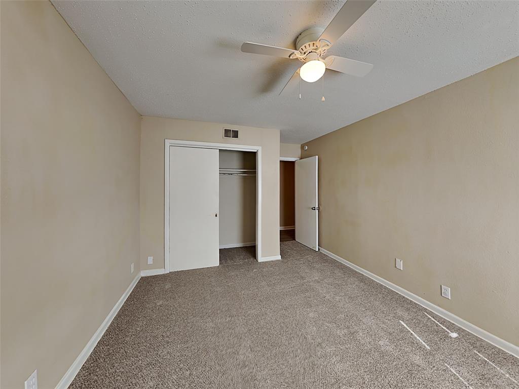 649 West Main Street Lancaster, TX 75146 - Photo 8 of 14 Unfurnished bedroom featuring carpet, a closet, ceiling fan, and a textured ceiling