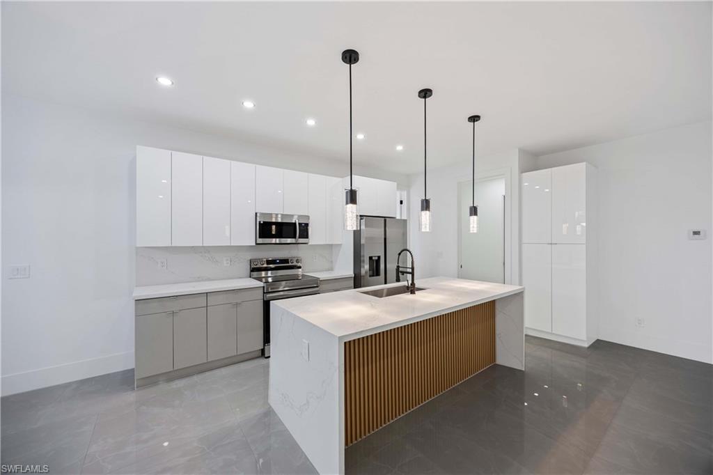 3908 Sunset Road Lehigh Acres, FL 33971 - Photo 12 of 30 a kitchen with a sink a stove and a refrigerator