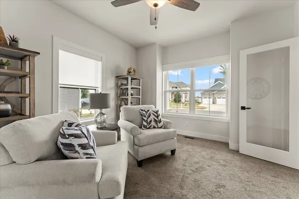 a kitchen with stainless steel appliances kitchen island granite countertop a sink a stove a refrigerator and white cabinets with wooden floor